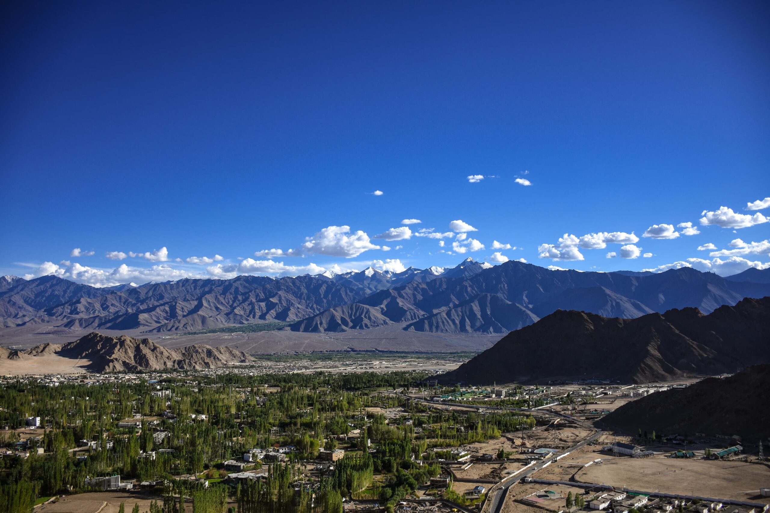 Scenic view of Leh, Ladakh with majestic mountains under a clear blue sky.
